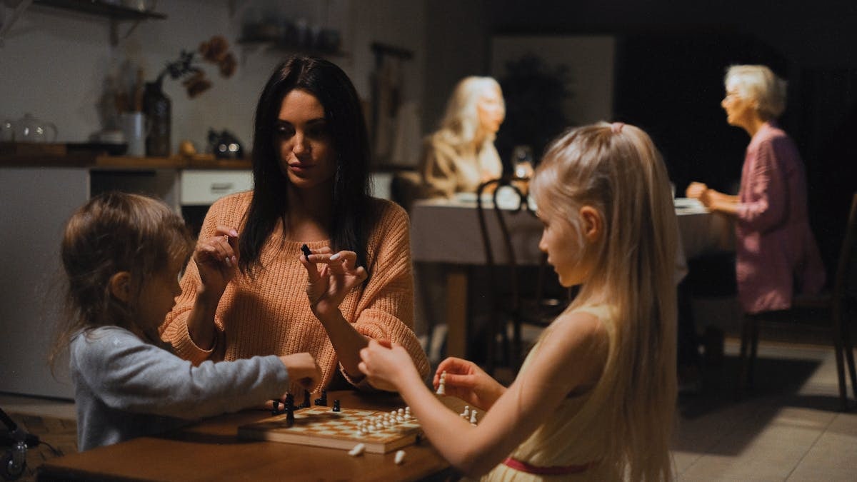 A family enjoys quality time playing chess together, fostering bonding and strategic thinking.